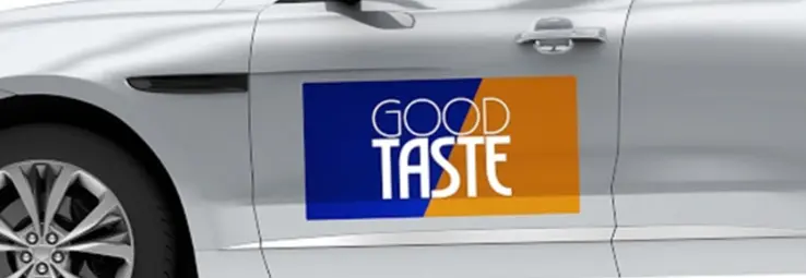 A car magnet saying "Good Taste" on a white car.