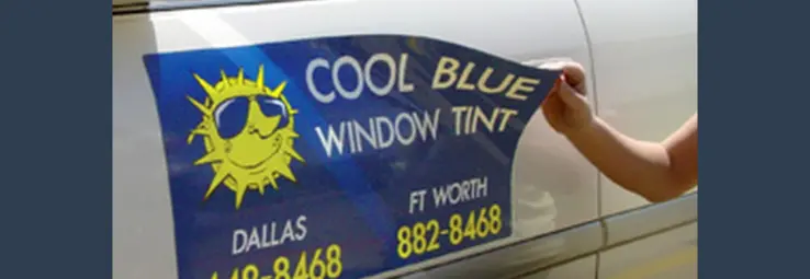 A blue car magnet being applied to the drivers door.