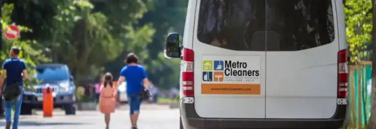 A parked bus of the metro cleaners with a car magnet on the back.
