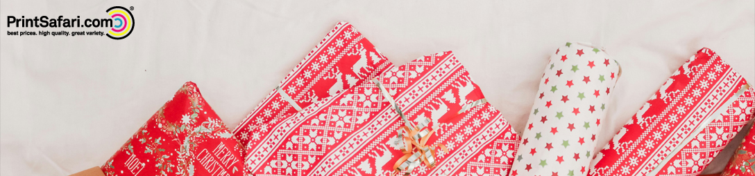 Wrapped Christmas gifts in red and white wrapping paper featuring a knitted sweater pattern with reindeer, stars, snowflakes, and the words 'Merry Christmas' in a festive design.