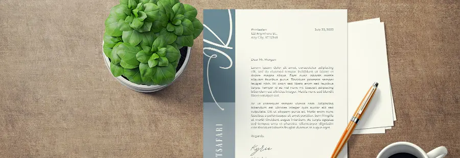 A blue and white letterhead on top of a brown surface next to a plant and a coffee mug.