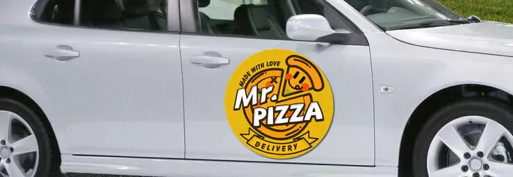 A round car magnet advertising a pizza restaurant.