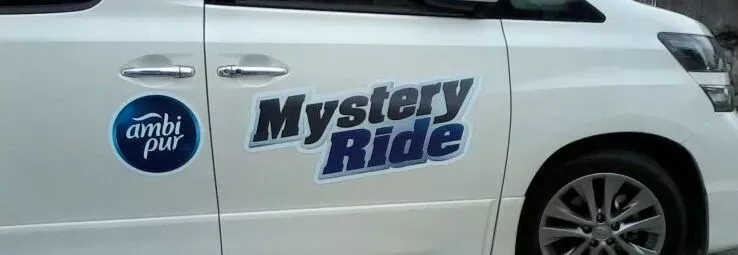 A car magnet applied on the front passengers door of a white van.