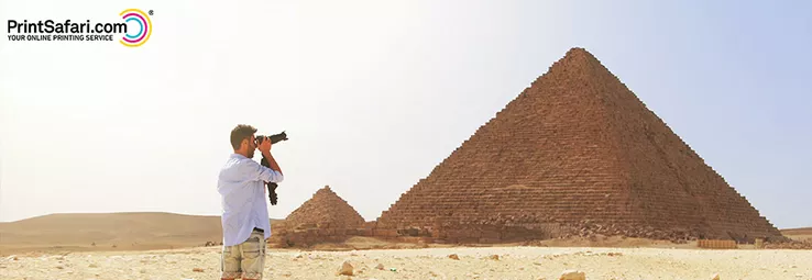 A tourist taking a picture of the great pyramids in giza.