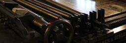 Close-up of an antique printing press, showcasing its intricate mechanical details and historical design.