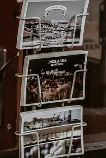 Various postcards displayed on a postcard stand in front of a store.