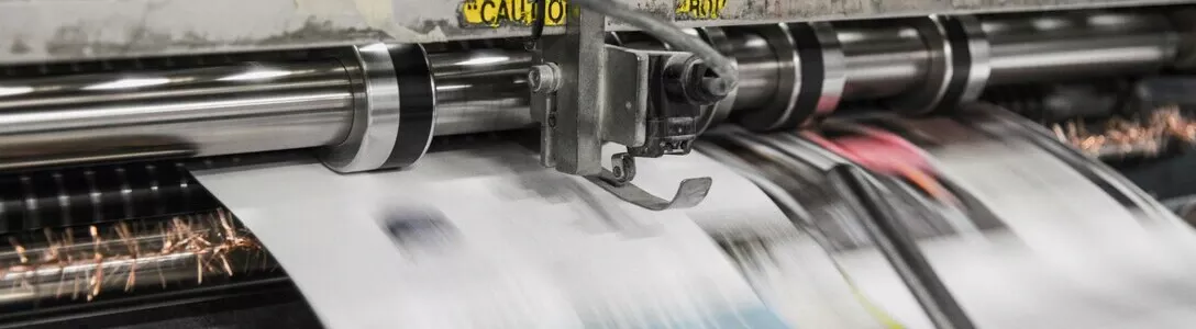 Modern printing press with mass production capacity, processing sheets so quickly that the content is blurred and unreadable in the image.