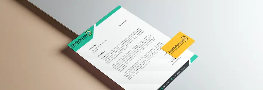 A customized letterhead and a business card laying on top of a silver surface.