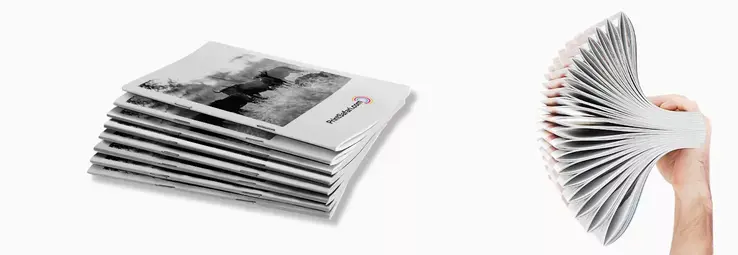 A stack of Magazines laying on top of each other and a hand holding another stack.