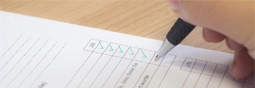 A hand checking an item of a checklist.