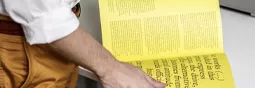 A man opening a perfect bound booklet.