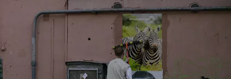 A man attaching a poster on a wall.