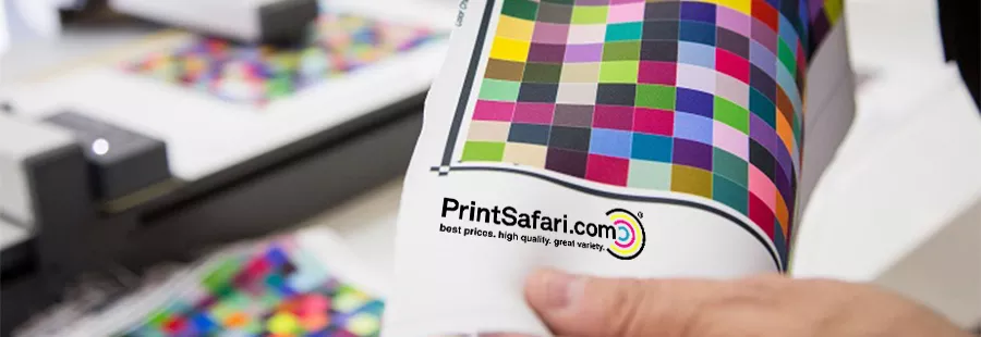 A hand presenting a canvas bag with a colorful print on the front.