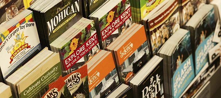 Different colorful brochures inside a brochure stand.