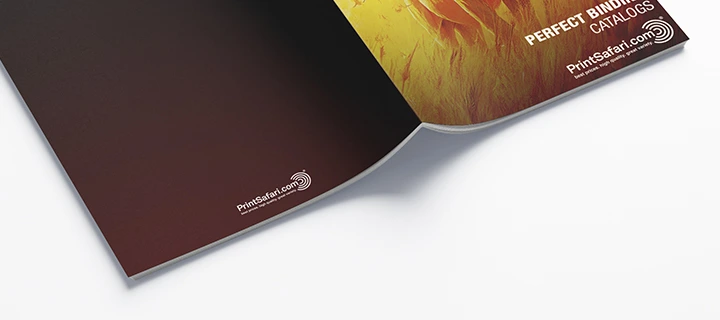 Open perfect-bound catalog with pages down and binding up, showing a detailed view of the perfect binding.