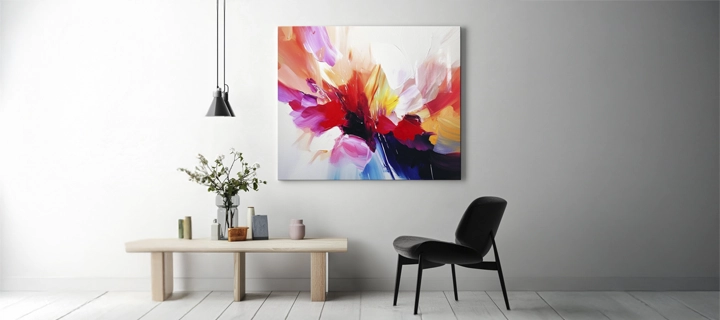 A colorful canvas print on a white wall, complemented by decor and a black chair in front.