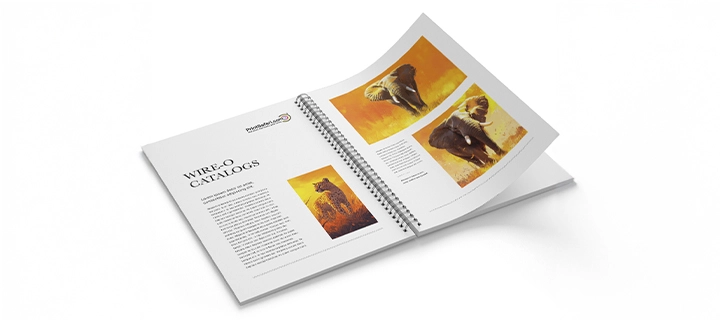 Open Wire-O bound catalog, showing the binding in the center of the pages. The left page has an introduction to an article with a picture of a cheetah, and the right page displays two large pictures of different elephants.