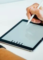 Designer creating catalog layout on digital tablet.