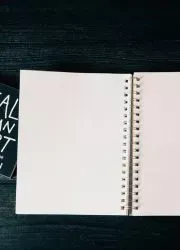 Open Wire-O catalog with blank pages and pencils.