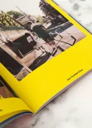 Open handbook with bold yellow pages and crisp photography