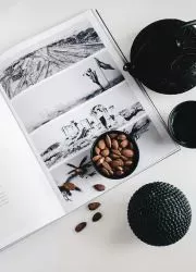 Open lookbook with black and white spreads, styled with coffee beans