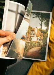 Flipping through a printed zine displaying colorful photography.