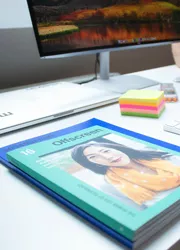 Catalog with perfect binding on a table in front of a computer for quality review.