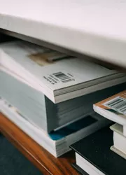 Received catalogs stacked on the shelf after successful bulk printing.