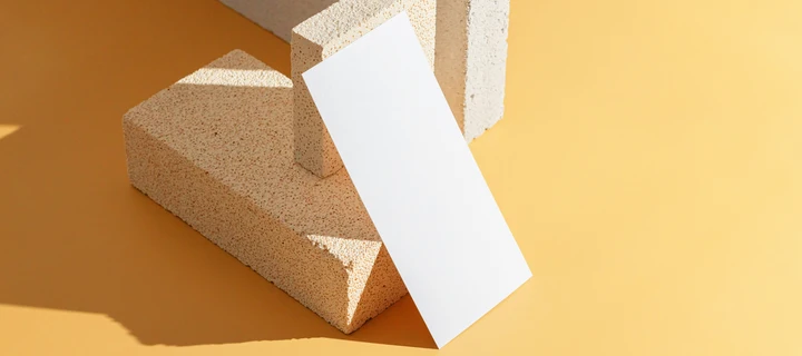 A white flyer leaning against a brick.