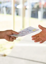 One hand handing a flyer to another hand