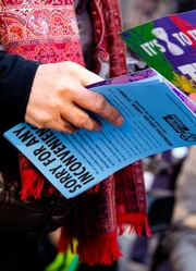 Hands holding several flyers.