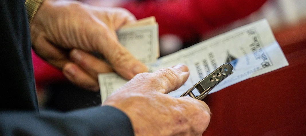 Two hands holding a ticket.