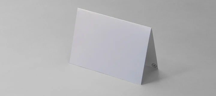 White folded business card standing on a flat surface