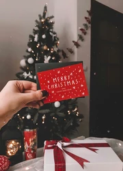 Business card with christmas design in front of a christmas tree