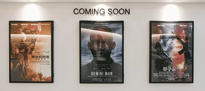 Three framed movie posters inside a cinema.