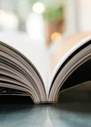 Open perfect-bound book showing a professional binding with clean white pages and a subtle center curve