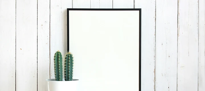 White Print with a black frame in front of a wall made out of wood.