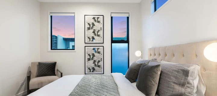 Two framed prints hanging on a bedroom wall.