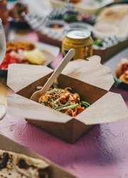 Snack Box standing on a table surrounded by food