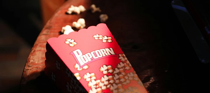 A red popcorn box laying on a table