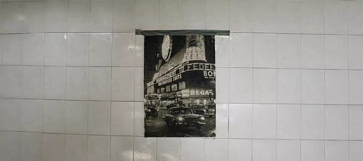 A poster taped to a white tiled wall.