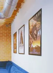 Row of framed movie posters mounted on brick and white walls