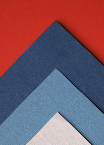 Dark blue, blue, and sand-colored custom wrapping paper displayed on a red carpet.