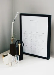 A framed year planner placed on a desk.