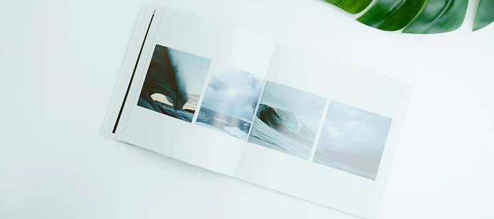 An open photography book lying on a white surface