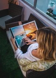 A woman holding a photography book and looking at it
