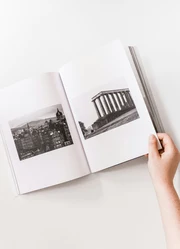 A hand flipping through the pages of a photography book