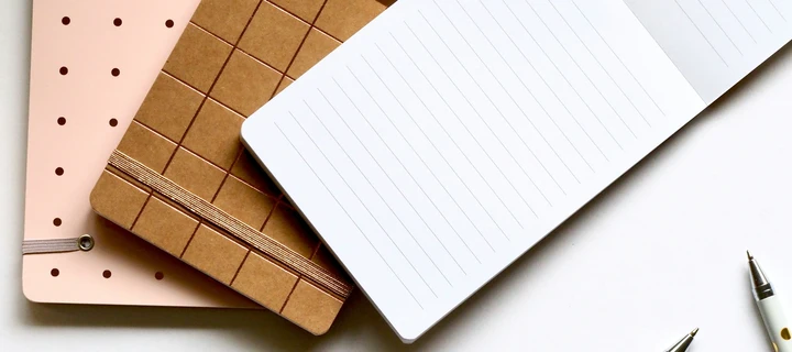 Two closed notepads and one open notepad