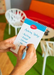 Hands of a person writing notes in a notepad