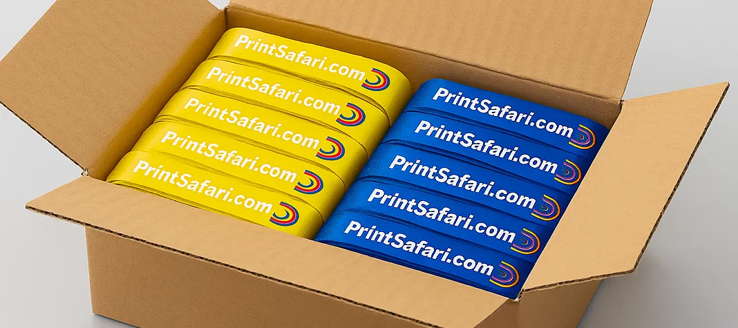 A cardboard box filled with a bulk order of blue Tyvek wristbands printed with the PrintSafari.com logo and tagline